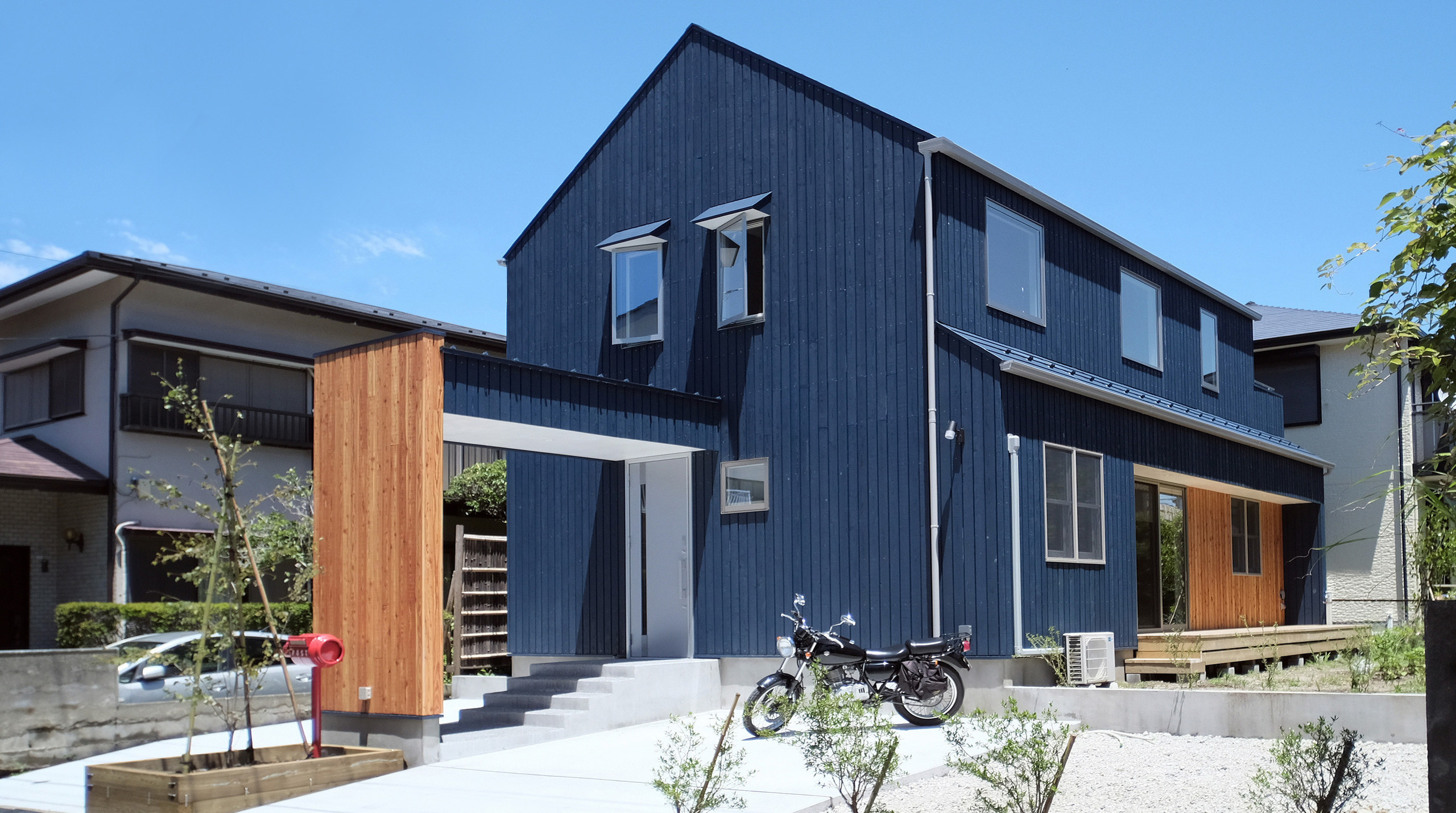 信州カラマツを用いたツーバイフォー工法の家。産地の顔が見える品質の高い信州カラマツ材を内外装に採用しています。屋外プランターや室内のハンモックネットなど随所にお客様のDIYが埋め込まれた住宅となっております。湘南の青い空に似合うブルー色を基調に家らしいフォルムを強調する三角屋根が印象的です。 | KIBARIの家　信州カラマツを使った吹抜けのある暮らし