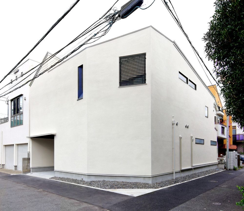 外観：高い壁に囲まれたようなシンプルなデザインに。正面には黒のルーバーや紺色の明かり窓がアクセントとなっている。 | CasaCadenza　シンプルに暮らす都会の家